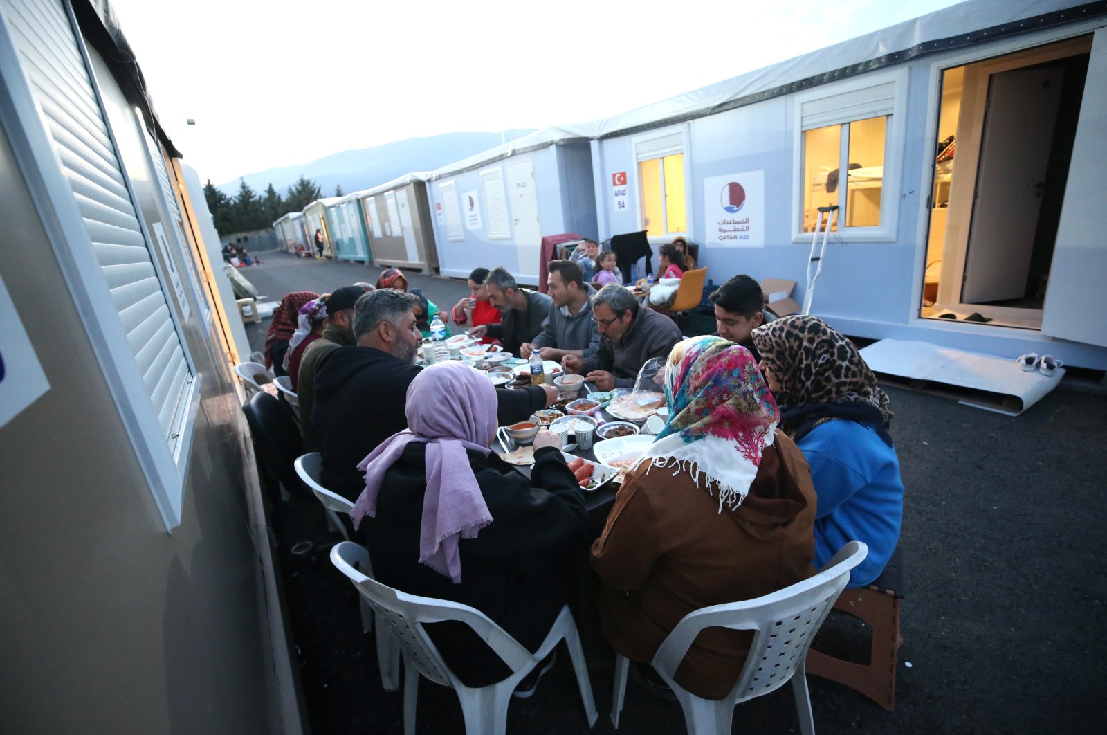 Survivors of the Feb. 6 twin earthquakes break their fast in a container city in Antakya, Hatay, southeastern Türkiye, March 23, 2023. (AA Photo)