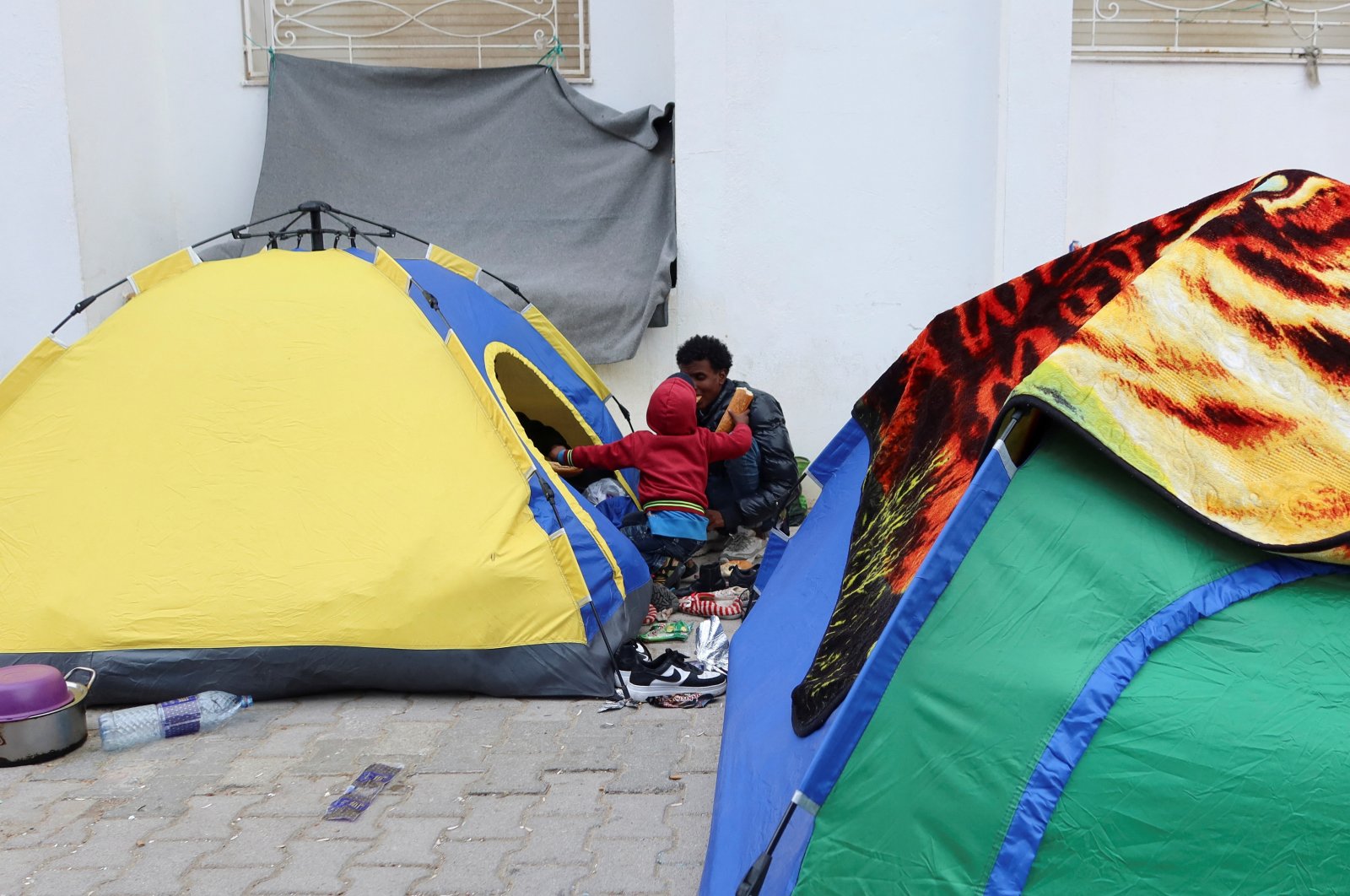 African migrants sit outside their tents at a temporary camp in Tunis, Tunisia, March 22, 2023. (Reuters Photo)