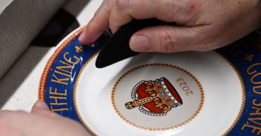 A pottery worker works on a range of fine bone china, designed to commemorate the coronation of Britain's King Charles III, at Duchess China 1888 in Longton, U.K., March 20, 2023. (AFP Photo)