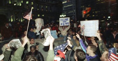 Supporters, with flags, and opponents, upper left, shout their opinions about the war in Iraq at a rally at Philadelphia&#039;s City Hall, the U.S., Jan. 17, 1991. (AP Photo)
