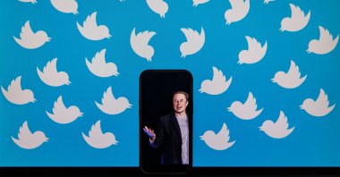 This file illustration photo shows a cellphone displaying a photo of Elon Musk placed on a computer monitor filled with Twitter logos in Washington, D.C., U.S., Aug. 5, 2022. (AFP Photo)