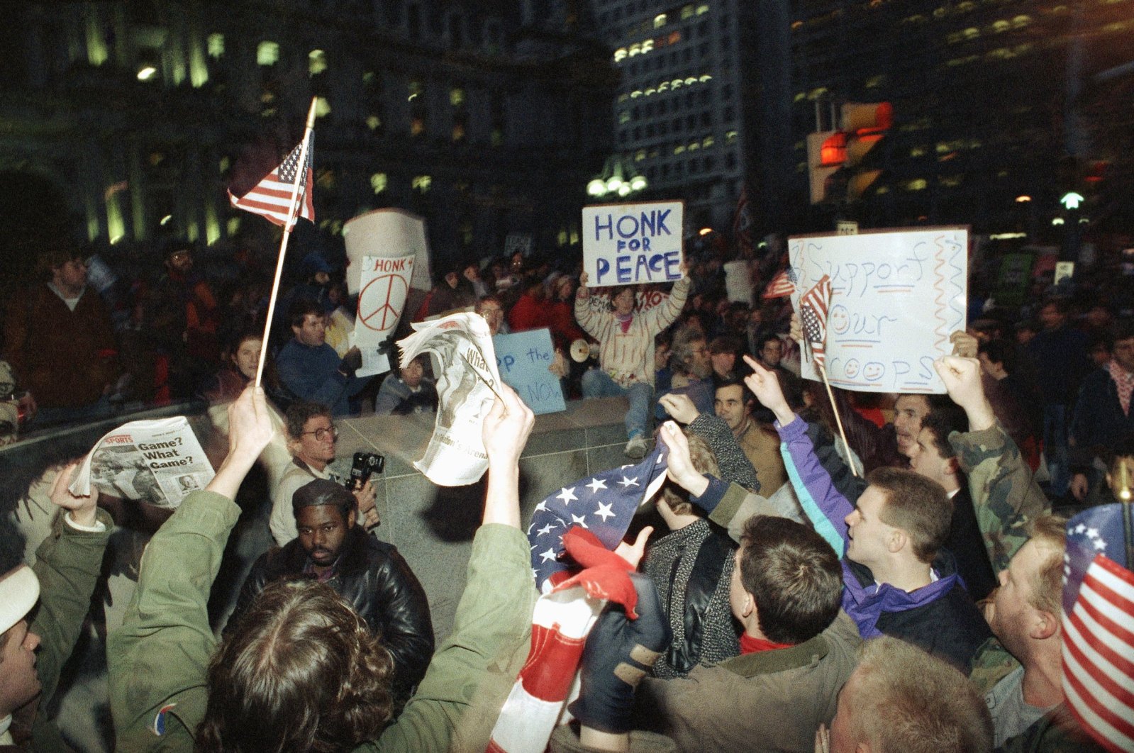 Supporters, with flags, and opponents, upper left, shout their opinions about the war in Iraq at a rally at Philadelphia&#039;s City Hall, the U.S., Jan. 17, 1991. (AP Photo)