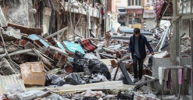 A boy walks among the ruble of collapsed buildings on the eve of Ramadan, in the aftermath of the powerful earthquakes in Kahramanmaraş, Türkiye, March 22, 2023. (EPA Photo)