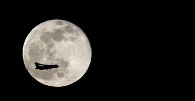 A plane crossing in front of the last full moon of the year is seen from Jinamar, in Gran Canaria, Spain, Dec. 19, 2021. (Reuters File Photo)