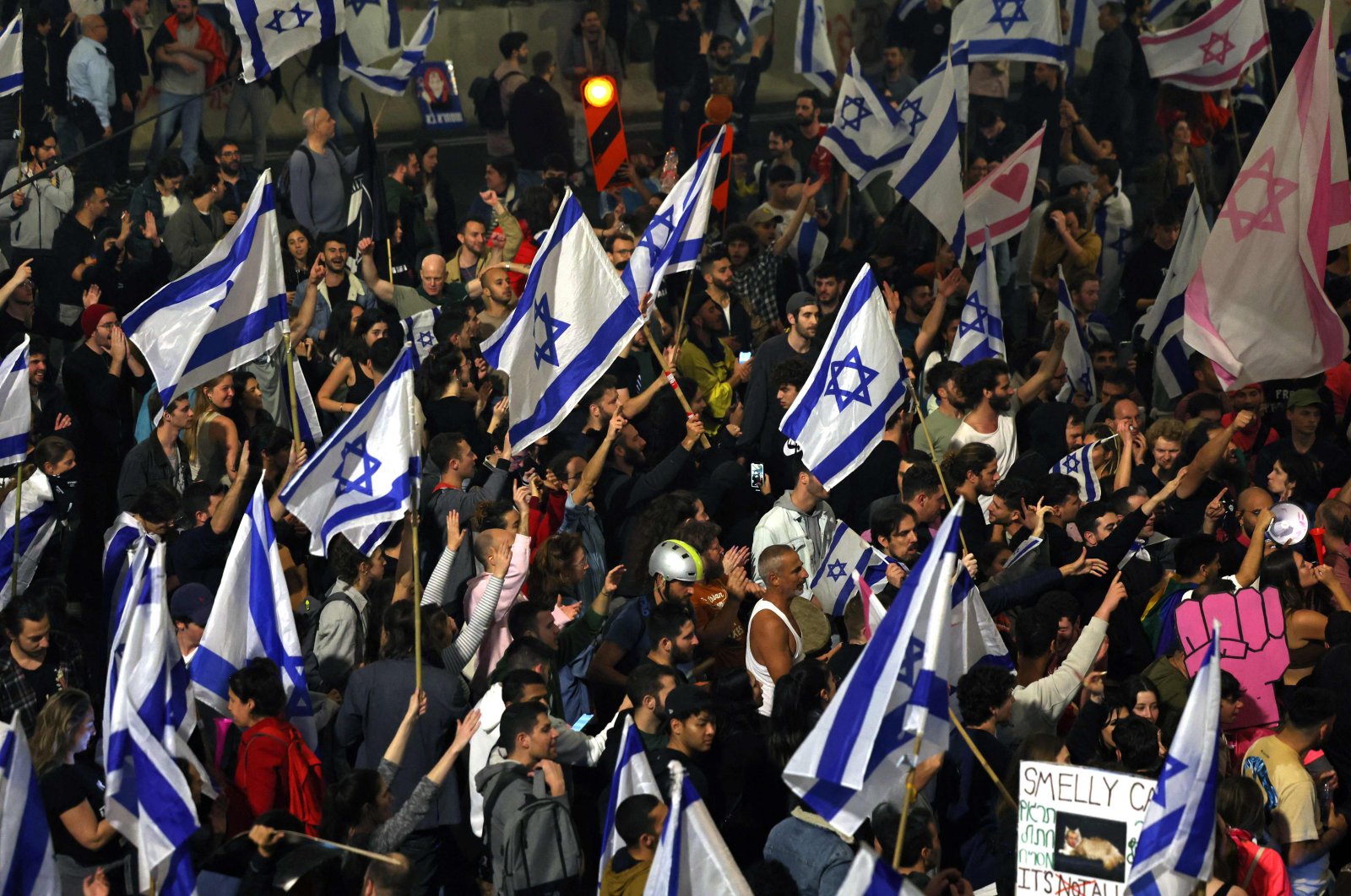 Protesters block a road and hold national flags during a rally against the Israeli government&#039;s judicial reform in Tel Aviv, Israel, March 27, 2023. (AFP Photo)