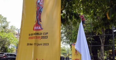 A worker removes a banner of FIFA U-20 World Cup 2023 at a main road, Denpasar, Bali, Indonesia, March 27, 2023. (EPA Photo)