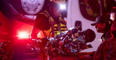 A migrant is carried to an ambulance after a fire broke out at the National Migration Institute (INM) center in Ciudad Juarez, Mexico, March 27, 2023. (Reuters Photo)