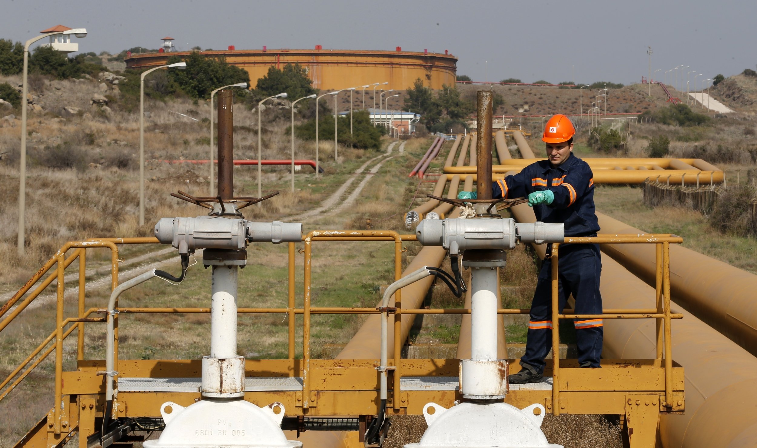 A worker checks the valve gears of pipes linked to oil tanks at the Mediterranean port of Ceyhan, which is run by the state-owned Petroleum Pipeline Corporation (BOTAS), some 70 kilometers (43.5 miles) from Adana, Türkiye, Feb. 19, 2014. (Reuters File Photo)
