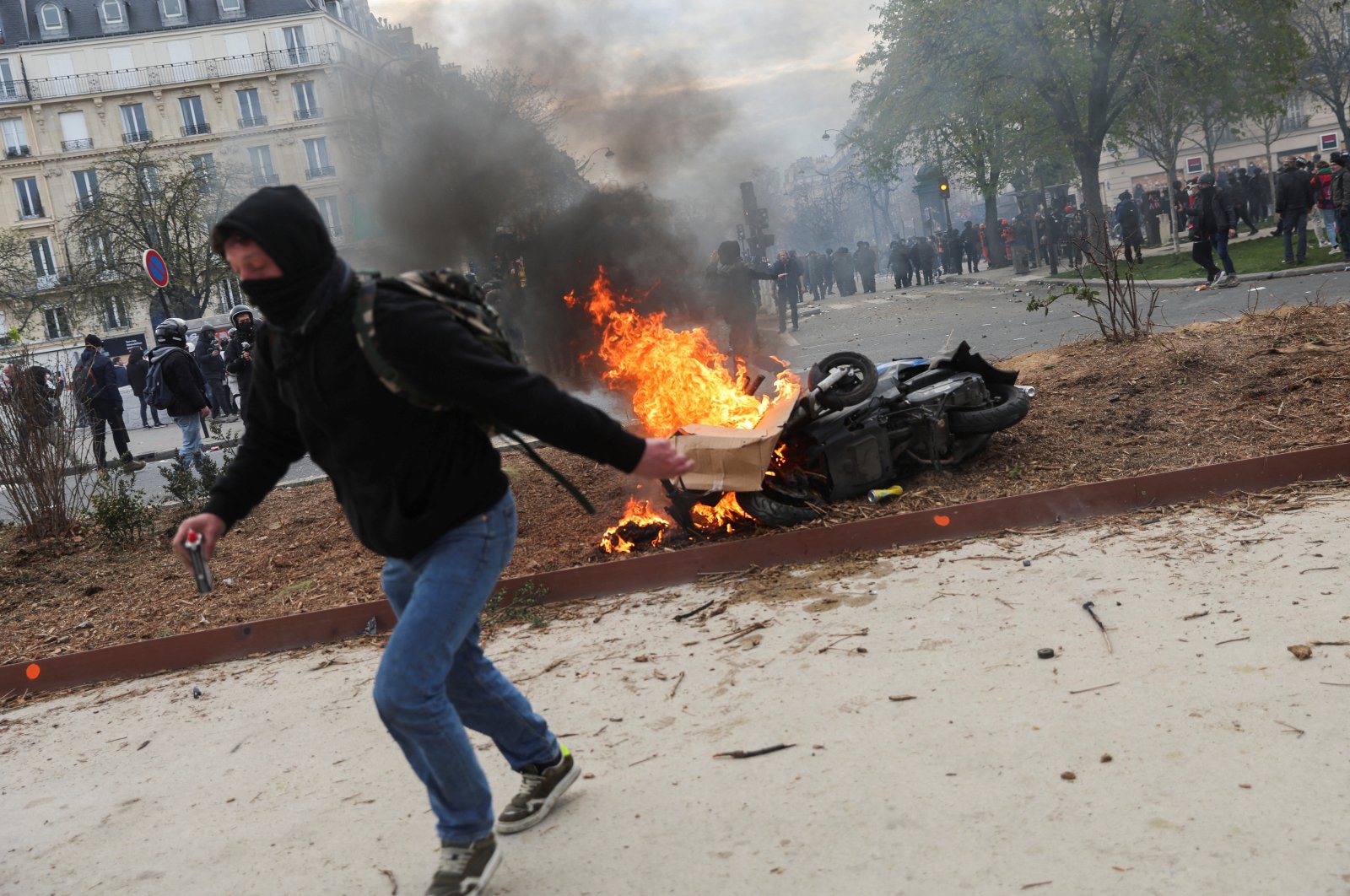 A protester runs next to a fire during clashes at a demonstration as part of the tenth day of nationwide strikes and protests against the French government&#039;s pension reform in Paris, France, March 28, 2023. (Reuters Photo)