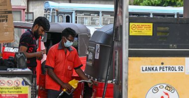 A worker fills petrol into an auto rickshaw at a fuel station in Colombo, Sri Lanka, March 29, 2023. (AFP Photo)