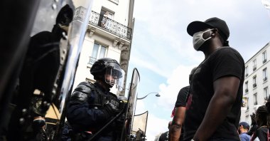 A protester wearing a face mask stands in front of police during a demonstration against racism and police brutality, in Paris, June 20, 2020. (AFP File Photo)