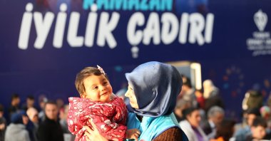 A volunteer of Türkiye Diyanet Foundation (TDV) holds a baby in a tent city in a quake zone, southeastern Türkiye, March 29, 2023. (IHA Photo)