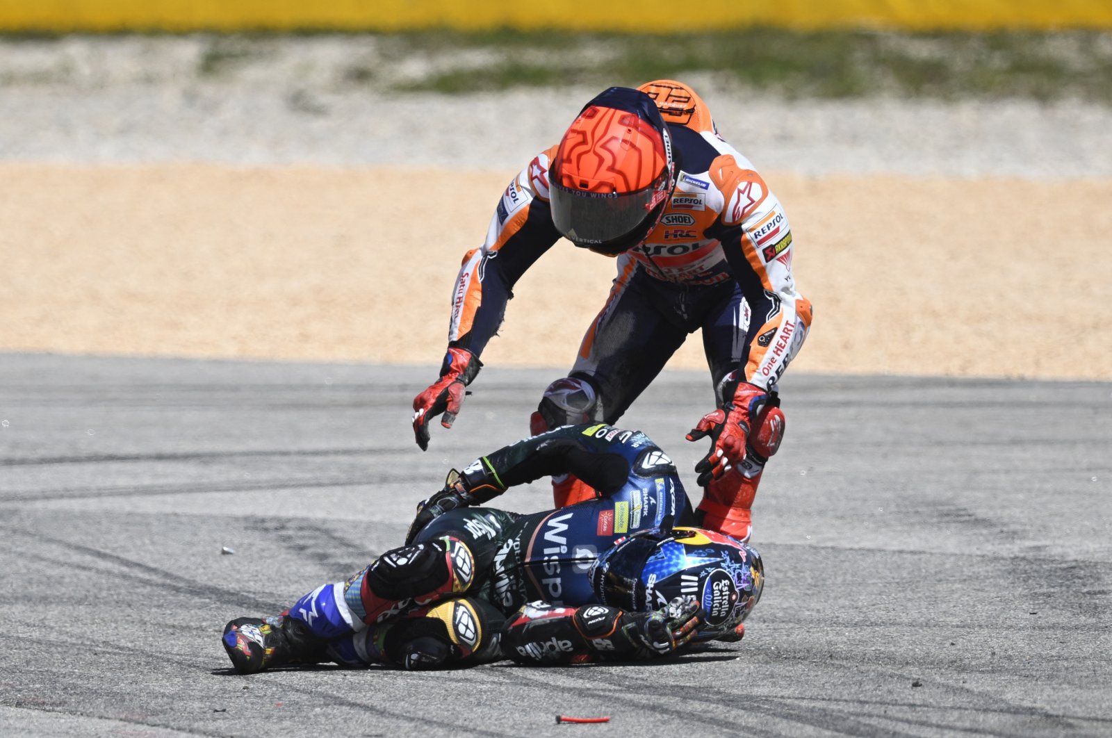 Honda Spanish rider Marc Marquez (R) checks on Aprilia Portuguese rider Miguel Oliveira after crashing during the MotoGP race of the Portuguese Grand Prix at the Algarve International Circuit, Portimao, Portugal, March 26, 2023. (AFP Photo)