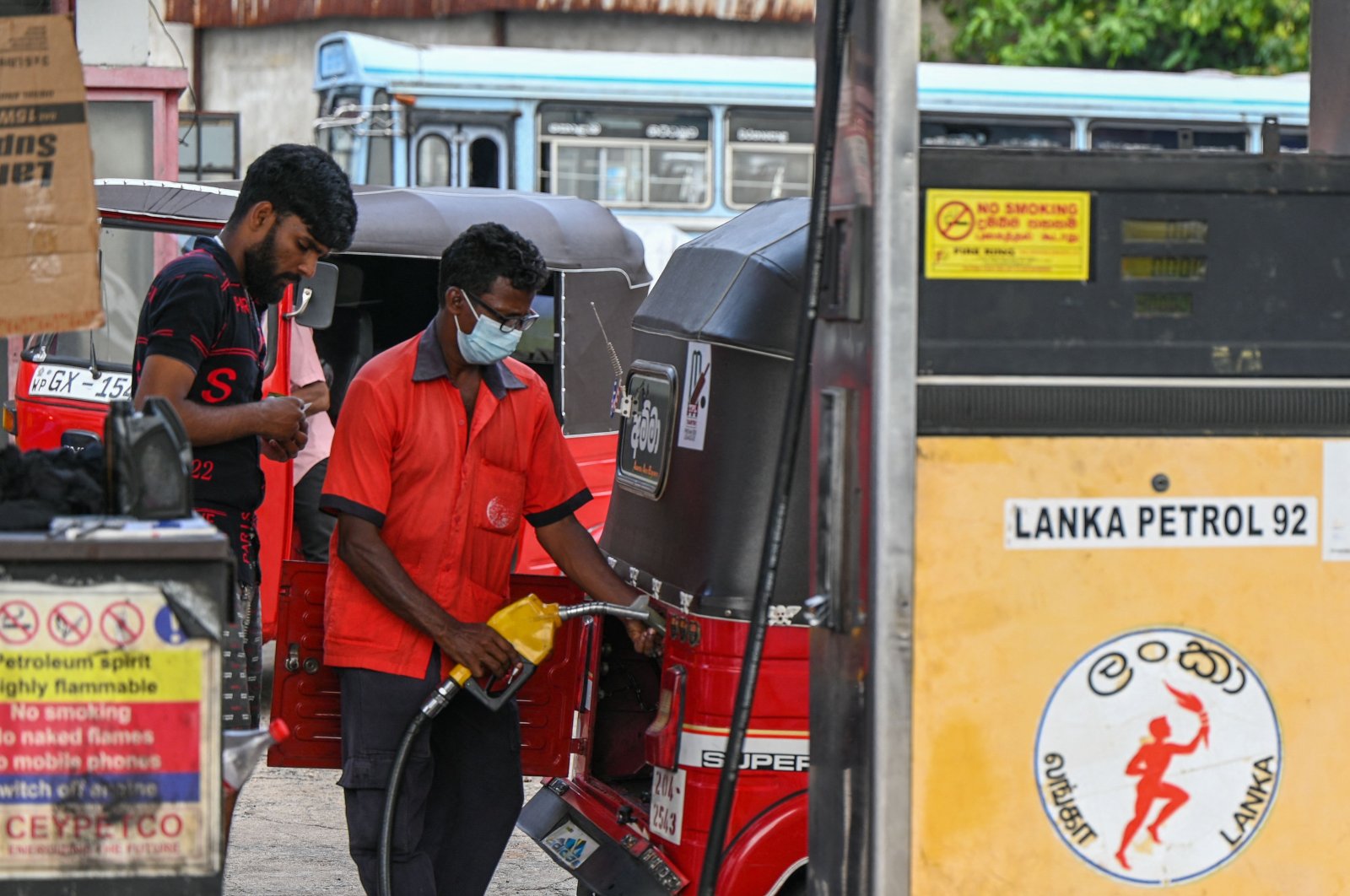 A worker fills petrol into an auto rickshaw at a fuel station in Colombo, Sri Lanka, March 29, 2023. (AFP Photo)