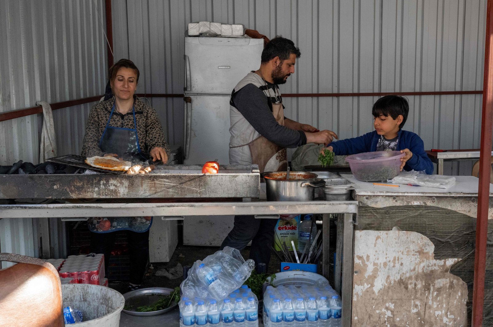 A family works at a street food restaurant in Hatay, Türkiye, March 28, 2023. (AFP Photo)