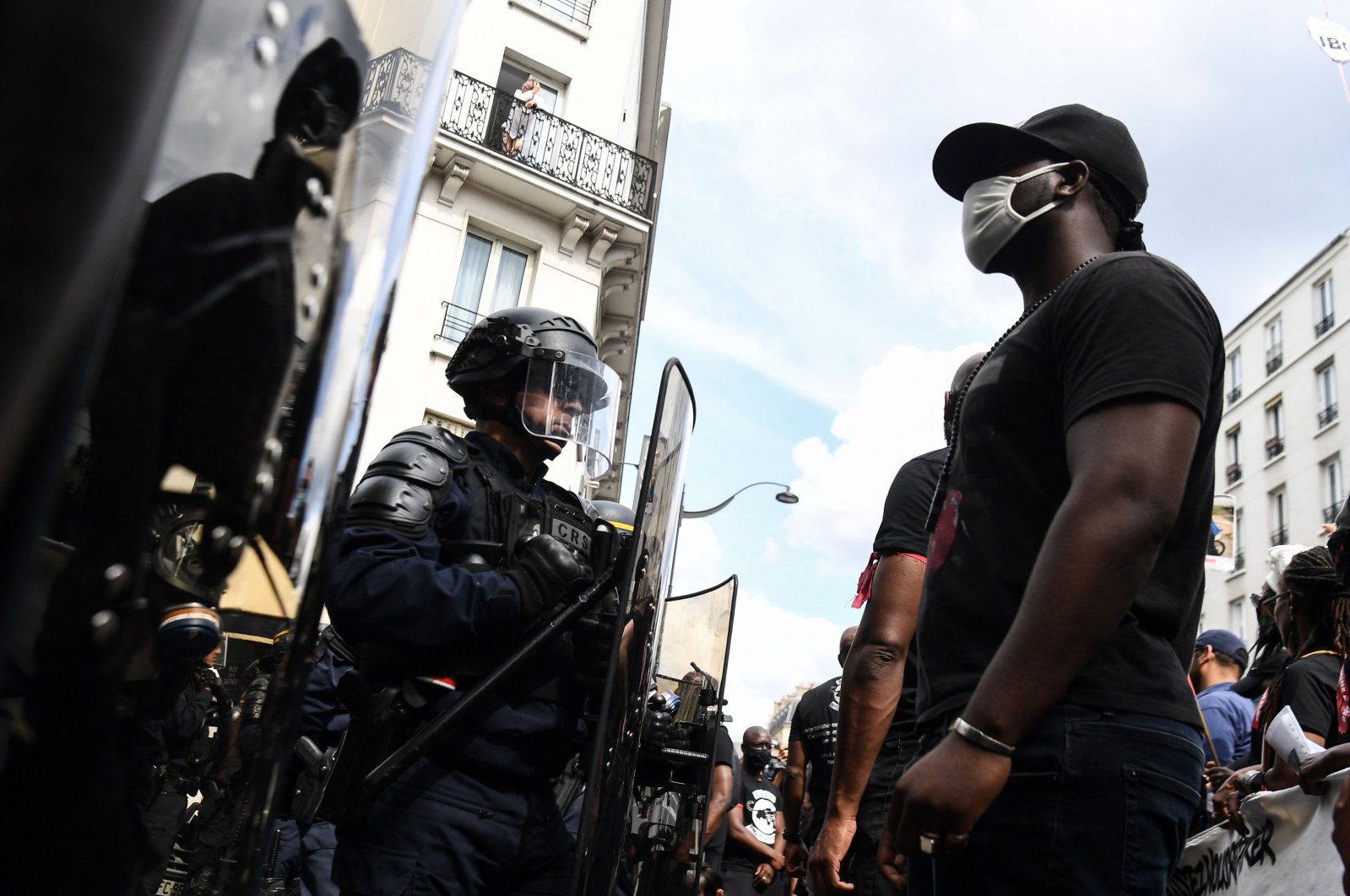 A protester wearing a face mask stands in front of police during a demonstration against racism and police brutality, in Paris, June 20, 2020. (AFP File Photo)