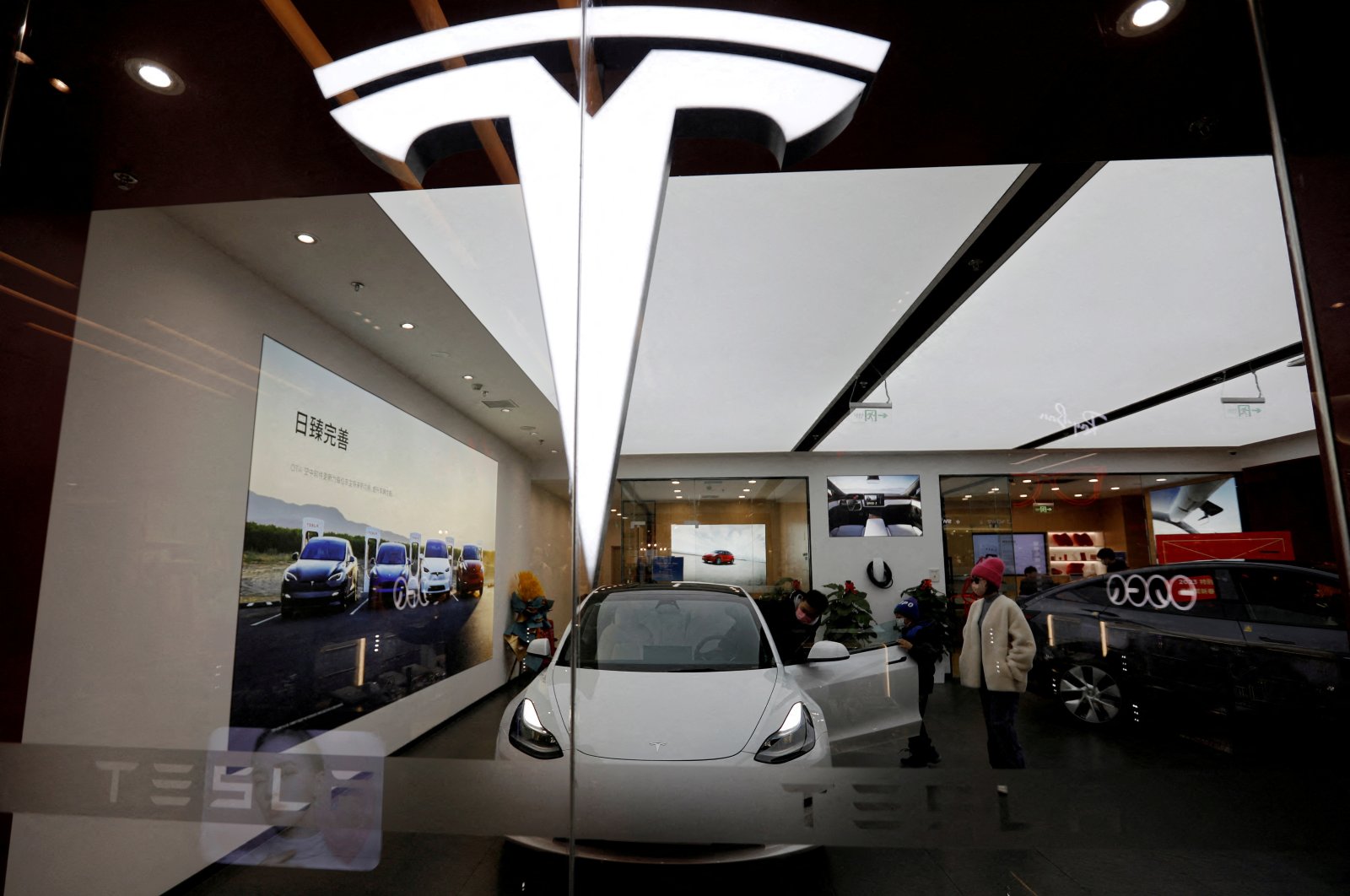 Visitors check a Tesla Model 3 car next to a Model Y displayed at a showroom of the U.S. electric vehicle (EV) maker in Beijing, China, Feb. 4, 2023. (Reuters Photo)
