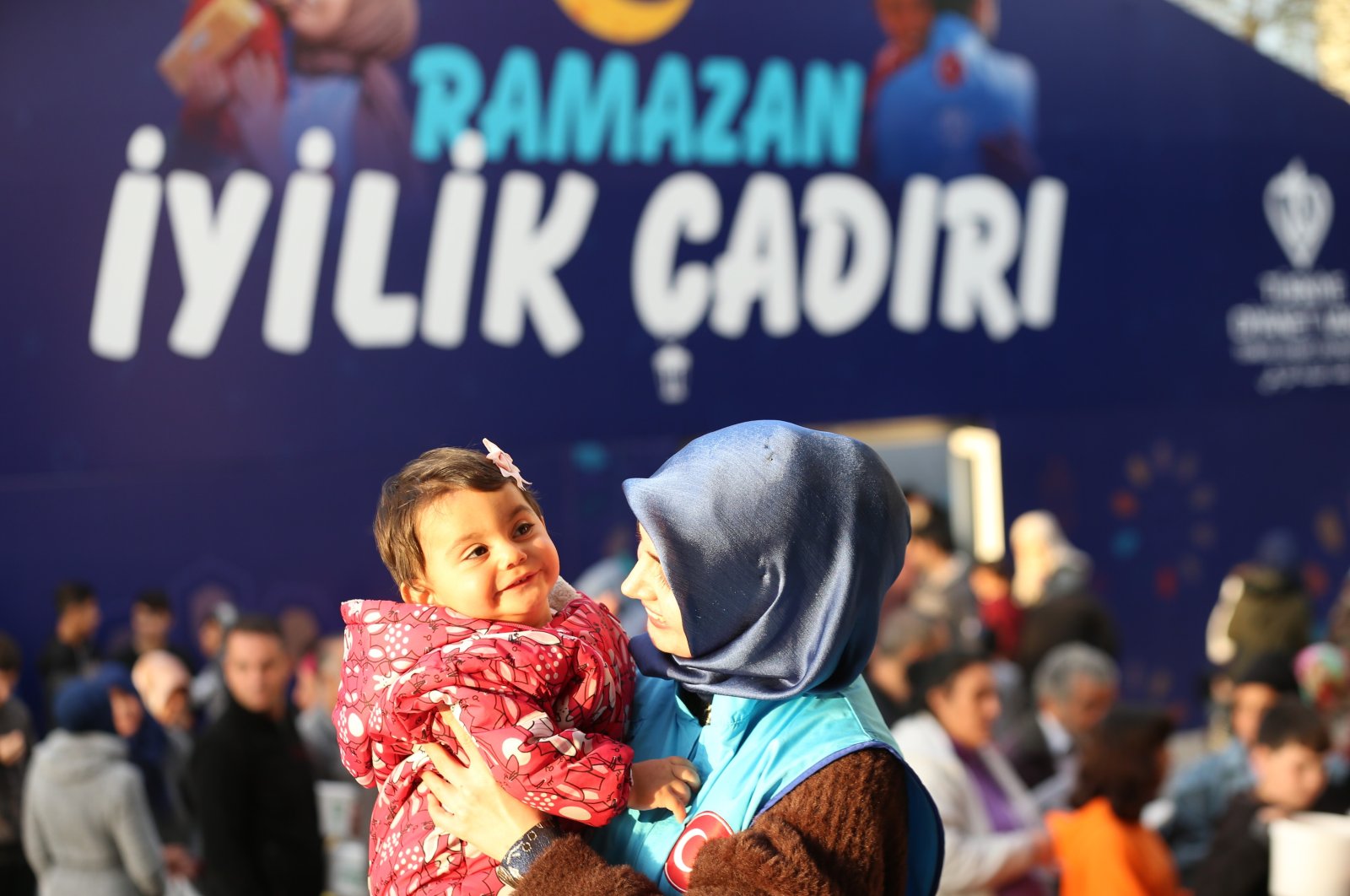 A volunteer of Türkiye Diyanet Foundation (TDV) holds a baby in a tent city in a quake zone, southeastern Türkiye, March 29, 2023. (IHA Photo)
