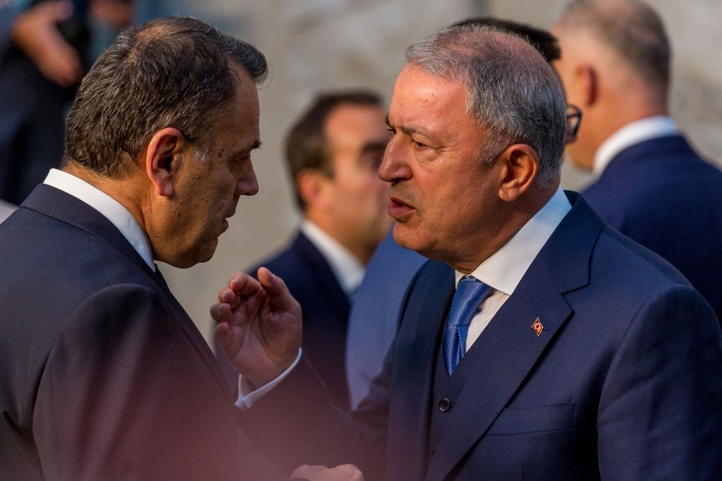 Turkish Defence Minister Hulusi Akar (R) speaks with Nikos Panagiotopoulos (L), in Brussels, Belgium, Jun. 16, 2022. (Getty Images)