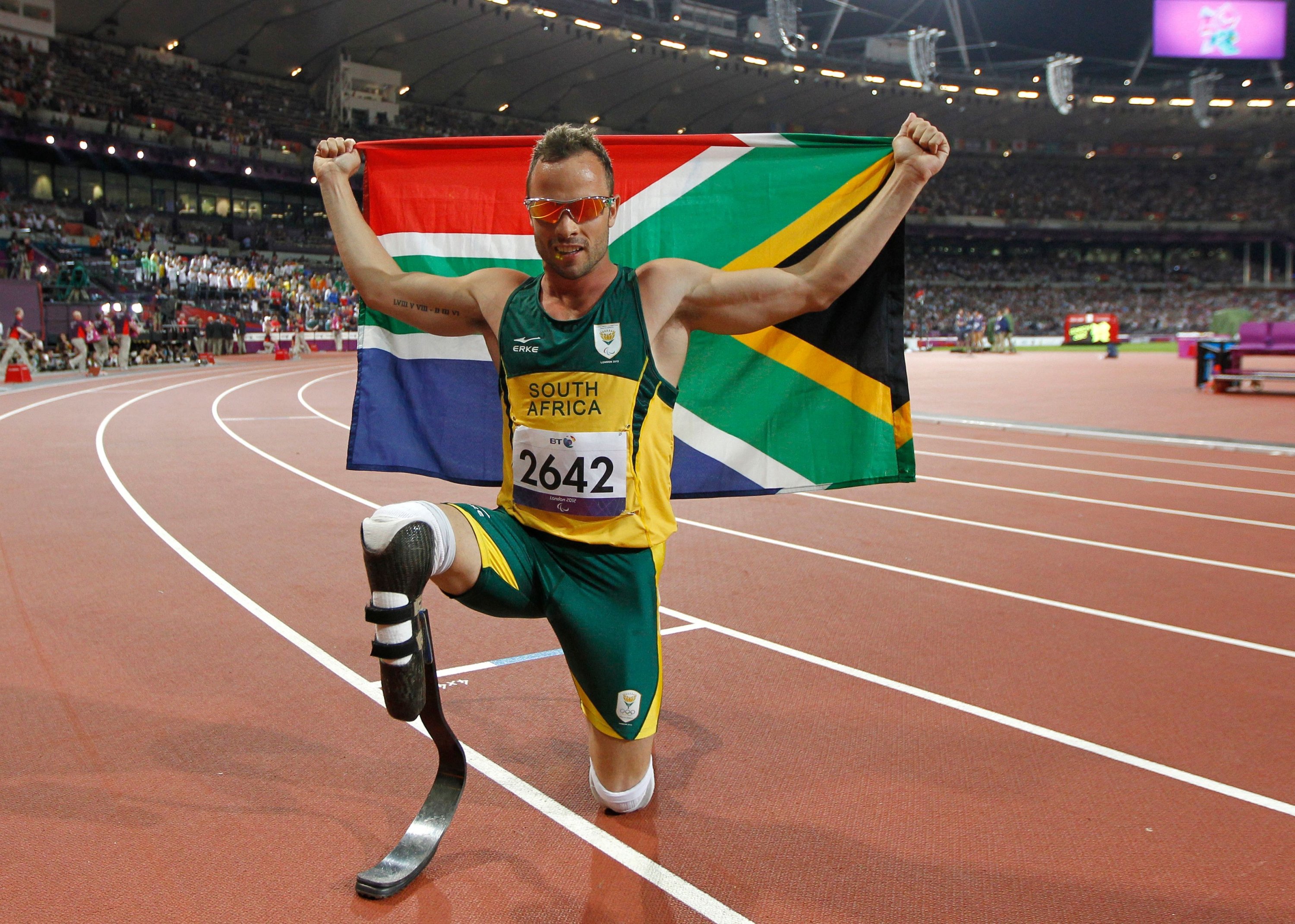 Oscar Pistorius dari Afrika Selatan berpose untuk foto dengan bendera nasional setelah memenangkan emas di final 400m-T44 putra selama kompetisi atletik di Paralympic Games London 2012, Stadion Olimpiade, London, Inggris, 9 September 2012. (AFP Photo)