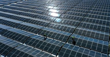 Workers assemble solar panels at a floating photovoltaic plant on the Silbersee lake in Haltern, western Germany, April 22, 2022. (AFP Photo)