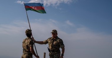 Two soldiers plant an Azerbaijani flag in the Shusha district of the Karabakh region after liberating it from Armenia in the 2020 Karabakh War, Azerbaijan, July 8, 2021. (Photo by Uğur Yıldırım)