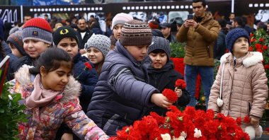 Children leave flowers to a memorial in memory of 1918 genocide victims, in Baku, Azerbaijan, Mar. 31, 2016. (AA Photo) 
