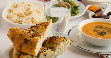 Bread pide of Ramadan on the iftar table near water and soup. (Shutterstock Photo)