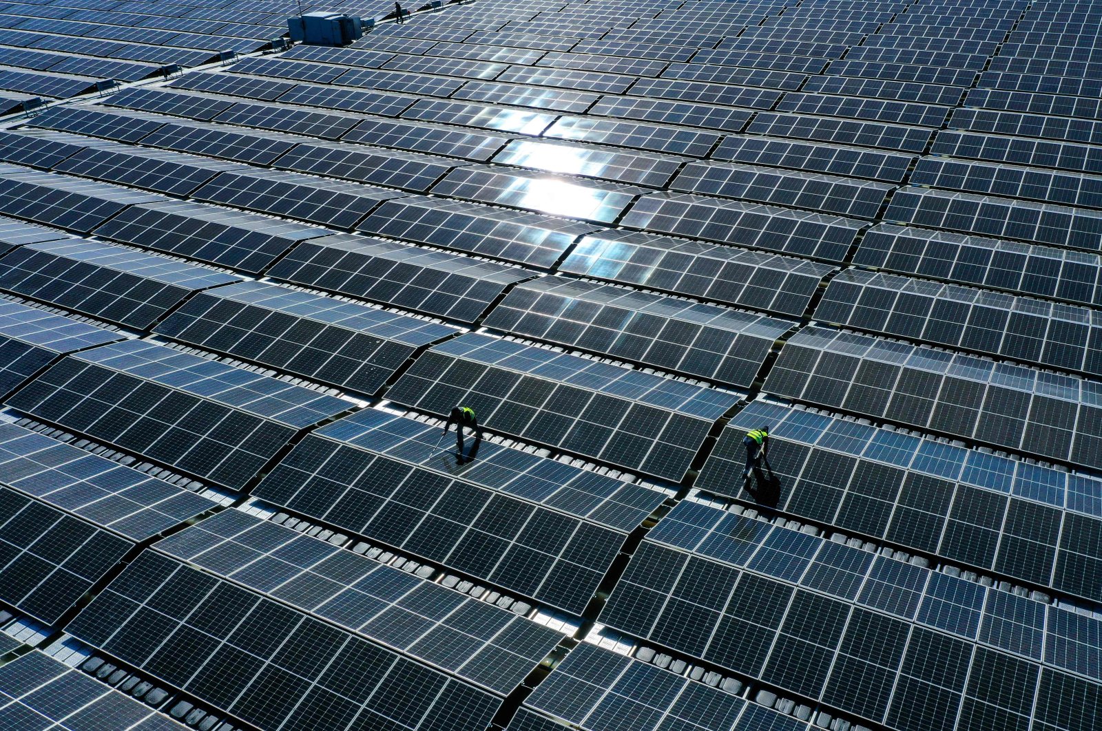 Workers assemble solar panels at a floating photovoltaic plant on the Silbersee lake in Haltern, western Germany, April 22, 2022. (AFP Photo)