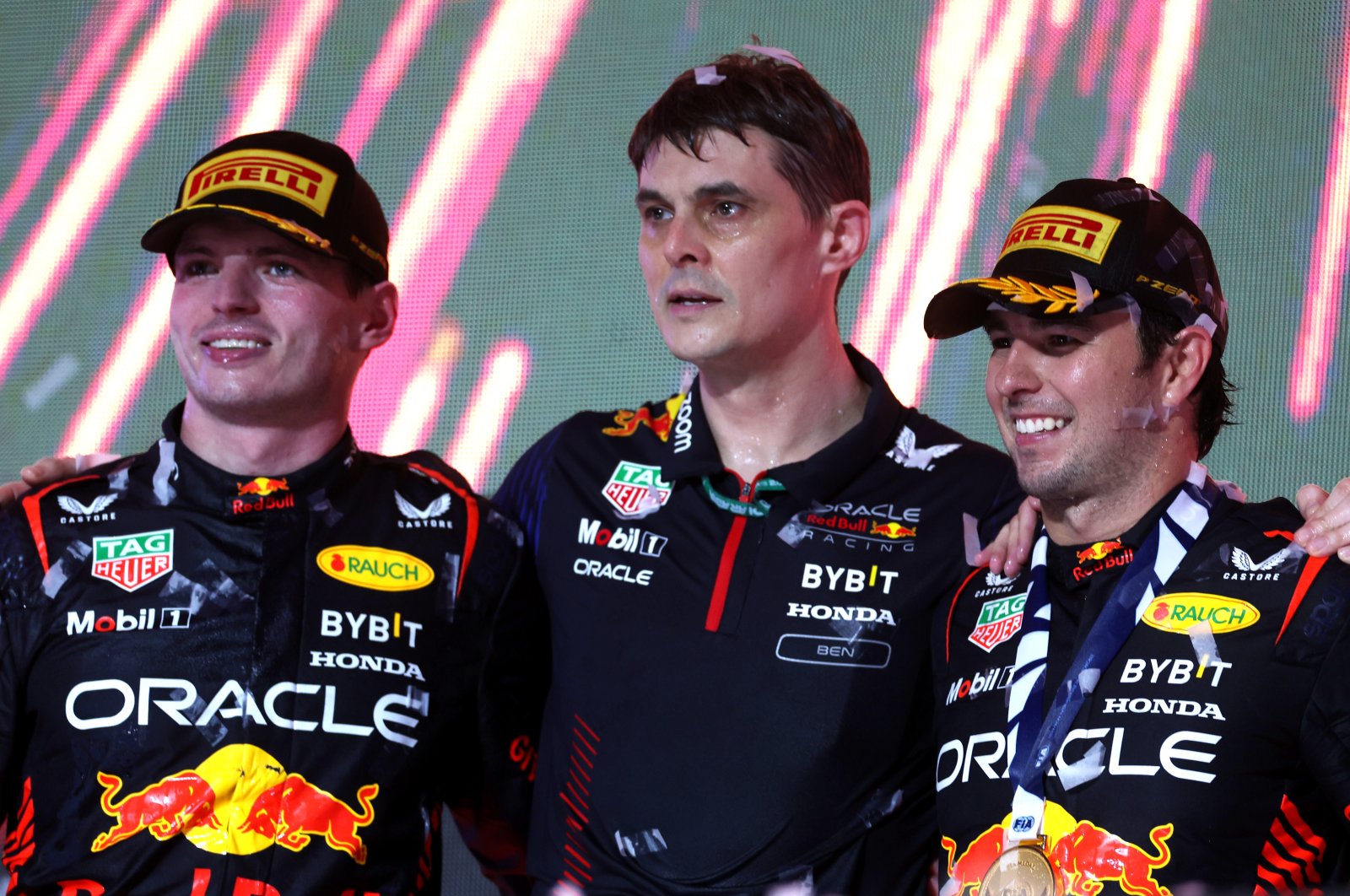 Oracle Red Bull Racing drivers Sergio Perez (R), Max Verstappen (L) and Head of Performance Engineering, Ben Waterhouse celebrate on the podium during the F1 Grand Prix of Saudi Arabia at Jeddah Corniche Circuit, Jeddah, Saudi Arabia, March 19, 2023. (Getty Images Photo)
