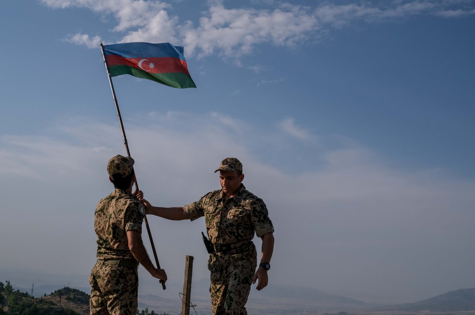 Two soldiers plant an Azerbaijani flag in the Shusha district of the Karabakh region after liberating it from Armenia in the 2020 Karabakh War, Azerbaijan, July 8, 2021. (Photo by Uğur Yıldırım)