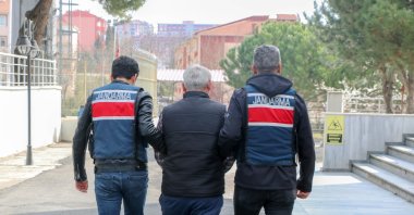Gendarmerie officers escort one of the five suspects from the Gülenist Terror Group (FETÖ) and the PKK apprehended while trying to cross into Greece from northwestern Edirne province, Türkiye, March 30, 2023. (DHA Photo)
