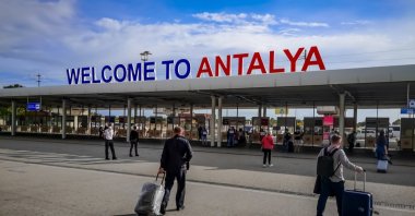 Tourists with suitcases walk towards the entrance of Antalya Airport, Antalya, Türkiye, Oct. 21, 2020. (Shutterstock Photo)