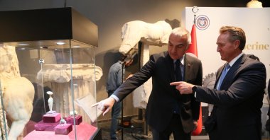 Culture Minister Mehmet Nuri Ersoy (L) and U.S. Ambassador to Ankara Jeff Flake (R) are seen along repatriated artifacts in Antalya, southern Türkiye, March 31, 2023. (DHA Photo)