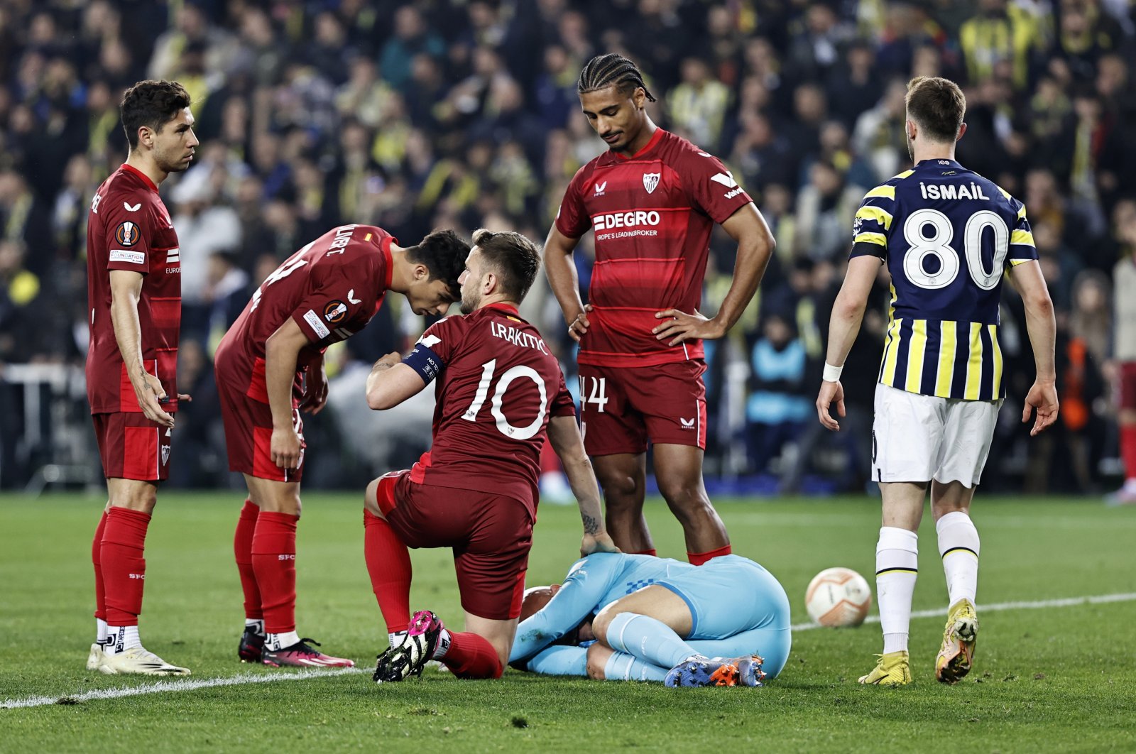 Sevilla players surround goalkeeper Marko Dmitrovic on the ground after he was hit by a foreign object during a Europa tie against Fenerbahçe, Istanbul, Türkiye, March 16, 2023. (AA Photo)