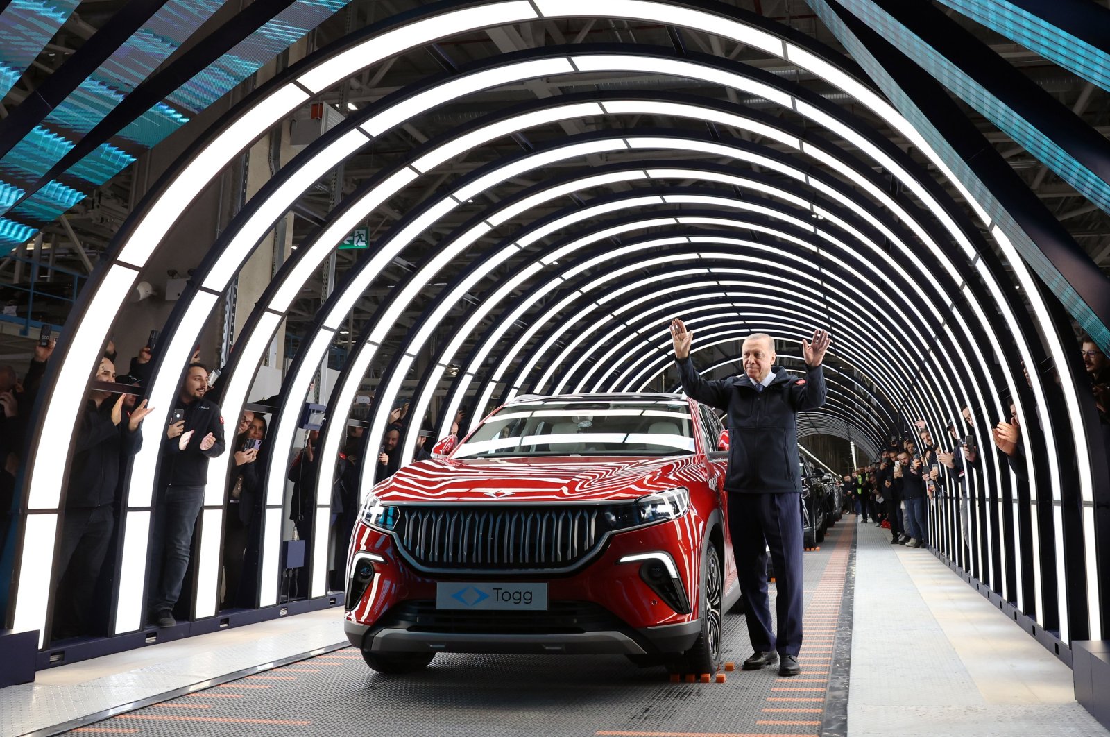 President Recep Tayyip Erdoğan stands alongside an SUV model of Türkiye&#039;s first domestic car brand Togg after the launch of its mass production in Bursa, northwestern Türkiye, Oct. 29, 2022. (AA Photo)