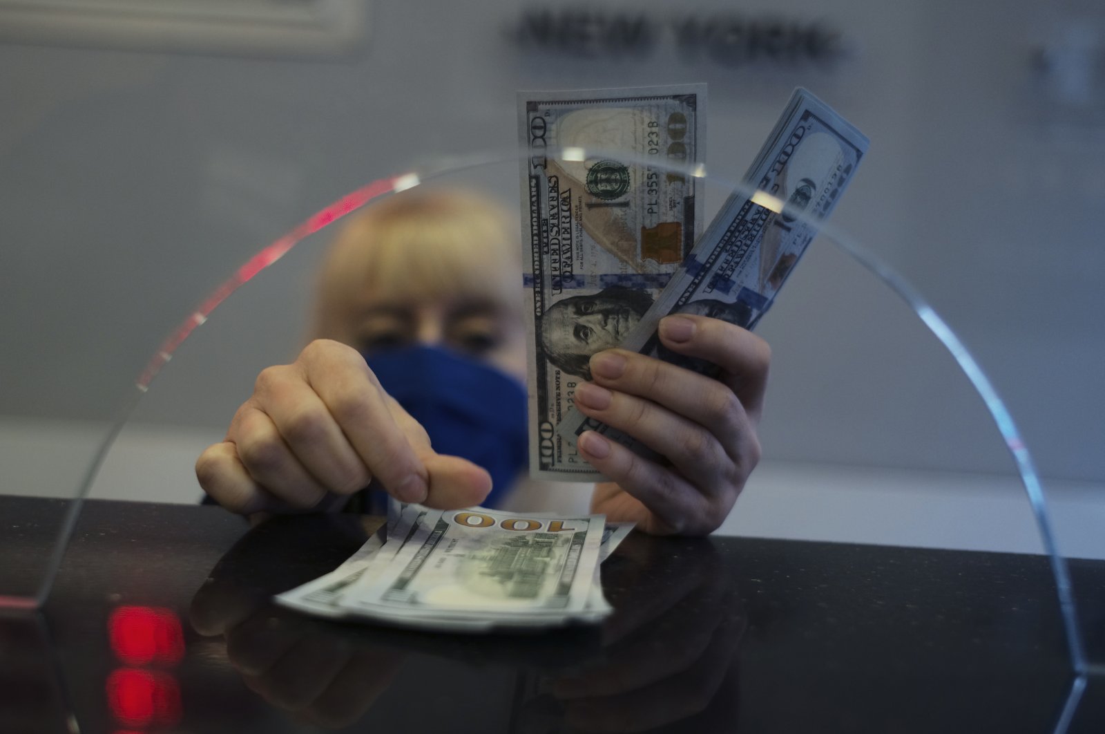 A woman counts U.S. dollar banknotes inside a currency exchange shop, in Ankara, Türkiye, March 22, 2021. (AP Photo)