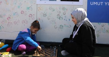 A psychologist engages a child with a gaming activity in the "Kalyon Container City," Islahiye, Gaziantep, Türkiye, April 5, 2023. (AA Photo)