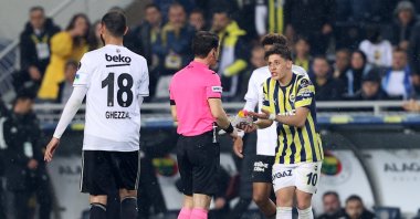 Fenerbahçe football player Arda Güler (R) shows his boots to the referee, Halil Umut Meler during Süper Lig match against Beşiktaş, Istanbul, Türkiye, April 2, 2023. (AA Photo)