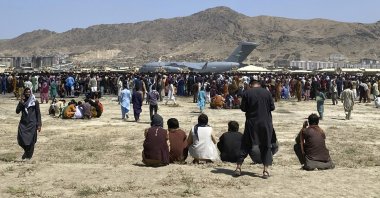 Hundreds of people gather near a U.S. Air Force C-17 transport plane at the perimeter of the international airport in Kabul, Afghanistan, Aug. 16, 2021. (AP Photo)