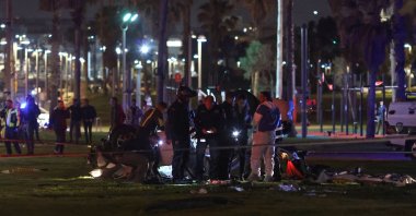 Israeli police gather around an overturned car at the site of an attack in Tel Aviv on April 7, 2023. (AFP Photo)