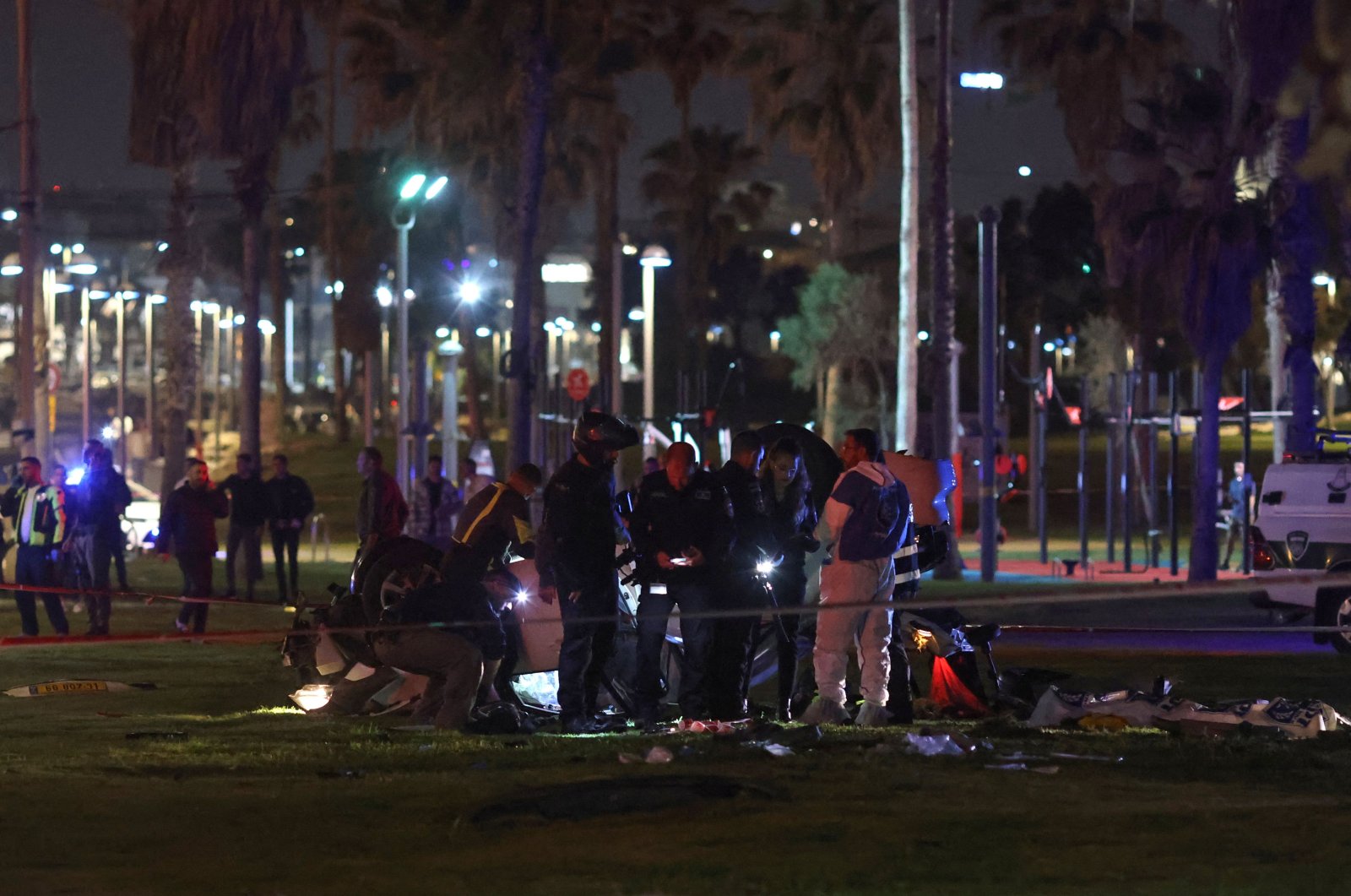 Israeli police gather around an overturned car at the site of an attack in Tel Aviv on April 7, 2023. (AFP Photo)