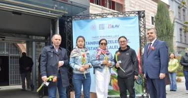 Tourists pose with tulips gifted to them by the Istanbul Tulip Foundation, Istanbul, Türkiye, April 9, 2023. (Photo courtesy of the Istanbul Tulip Foundation)