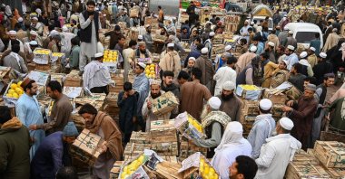 Shoppers, traders and individual buyers do business at a wholesale fruit market in Peshawar, Pakistan, April 2, 2023. (AFP Photo)