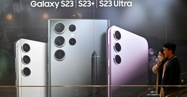 People walk past an advertisement for Samsung Galaxy S23 phones at the company's Seocho building in Seoul, South Korea, April 7, 2023. (AFP Photo)