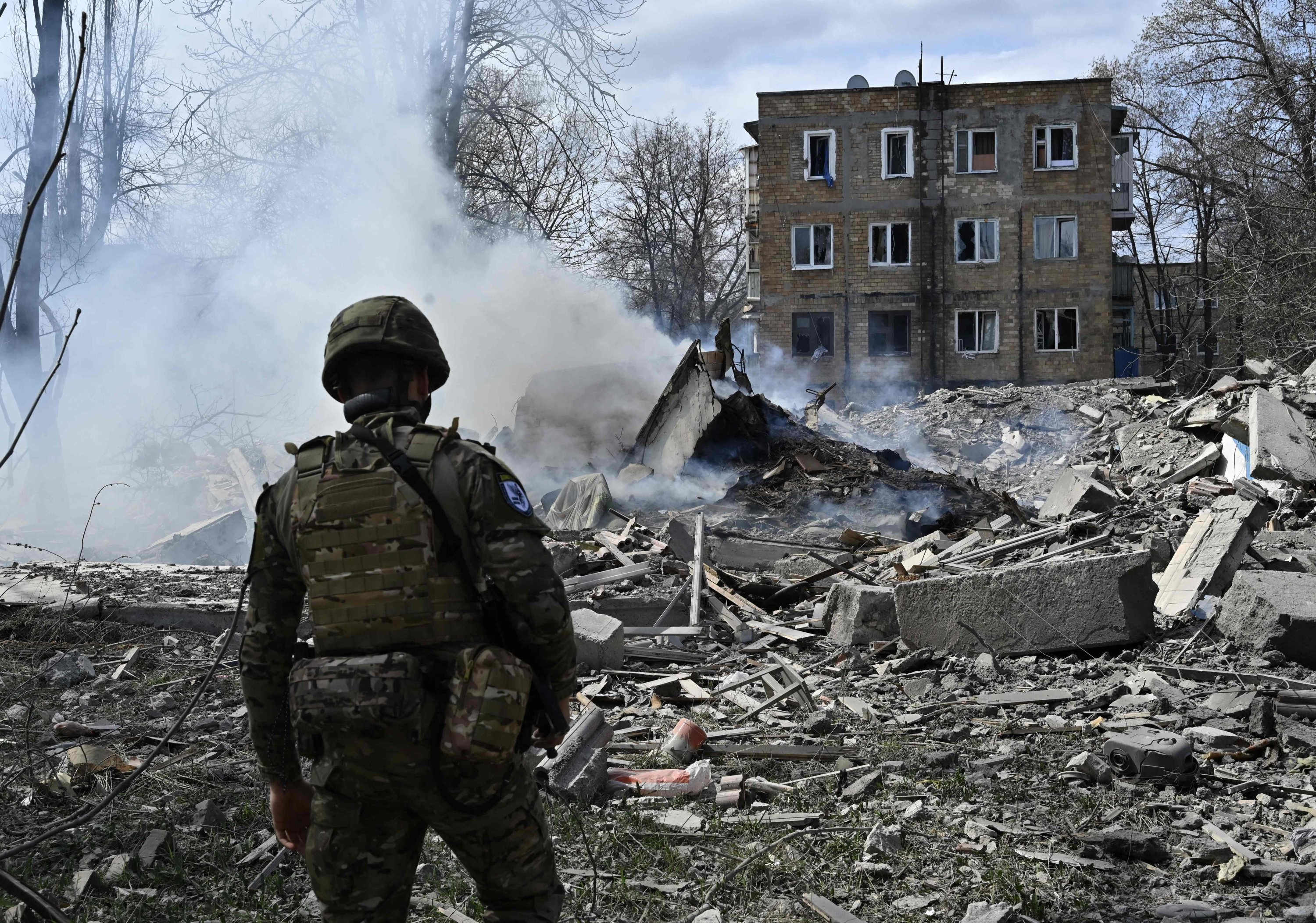 Seorang anggota Tim Polisi Khusus Malaikat Putih Ukraina melihat puing-puing bangunan tempat tinggal, Avdiivka, Donetsk, Ukraina, 10 April 2023. (Foto AFP)