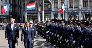 French President Emmanuel Macron (2nd L) and King Willem-Alexander of the Netherlands (L) review a guard of honor during a welcoming ceremony in The Hague, the Netherlands, April 11, 2023. (AFP Photo)