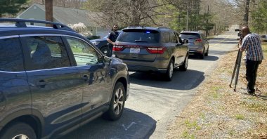 Vehicles move through a police blockade on a road in North Dighton, Massachusetts, U.S., April 13, 2023. (AP Photo)