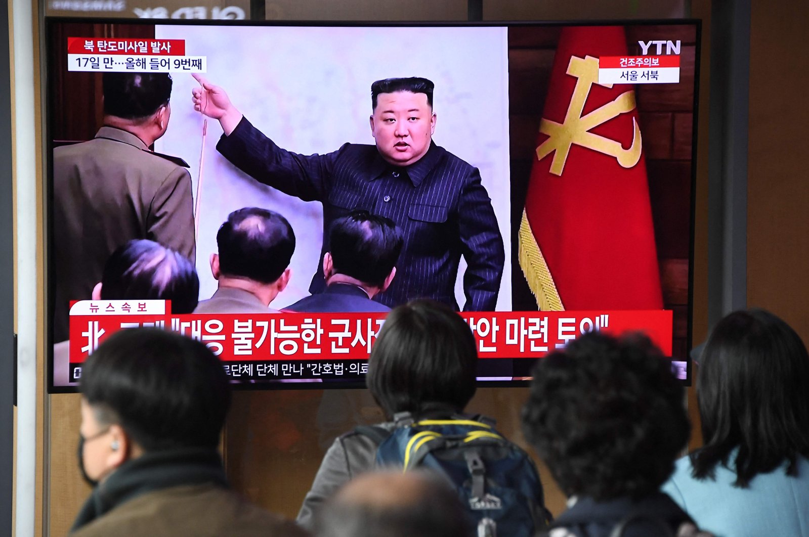 People watch a television screen showing a news broadcast with file footage of North Korean leader Kim Jong Un, at a railway station in Seoul, South Korea, April 13, 2023. (AFP Photo)