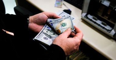 A worker counts U.S. dollars at an exchange office in Istanbul, Türkiye, April 14, 2023. (EPA Photo)